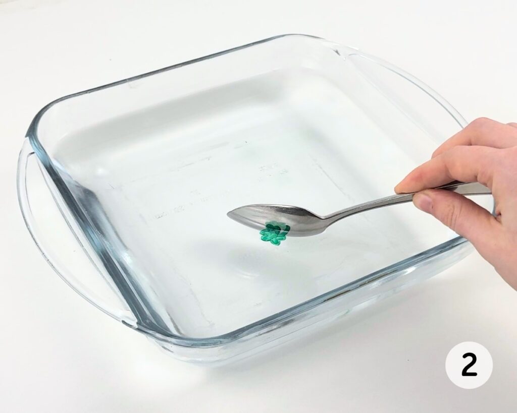 Shamrock drawing peeling off the spoon and into water.