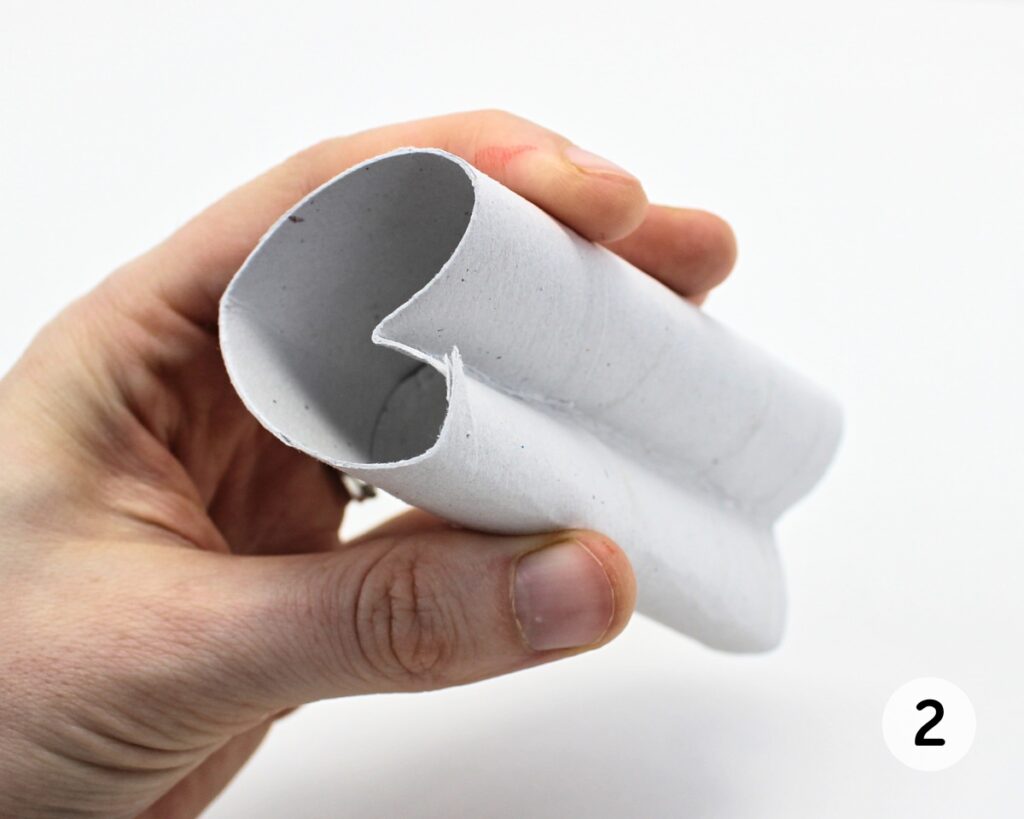 Hand holding a paper roll folded into the shape of a heart.