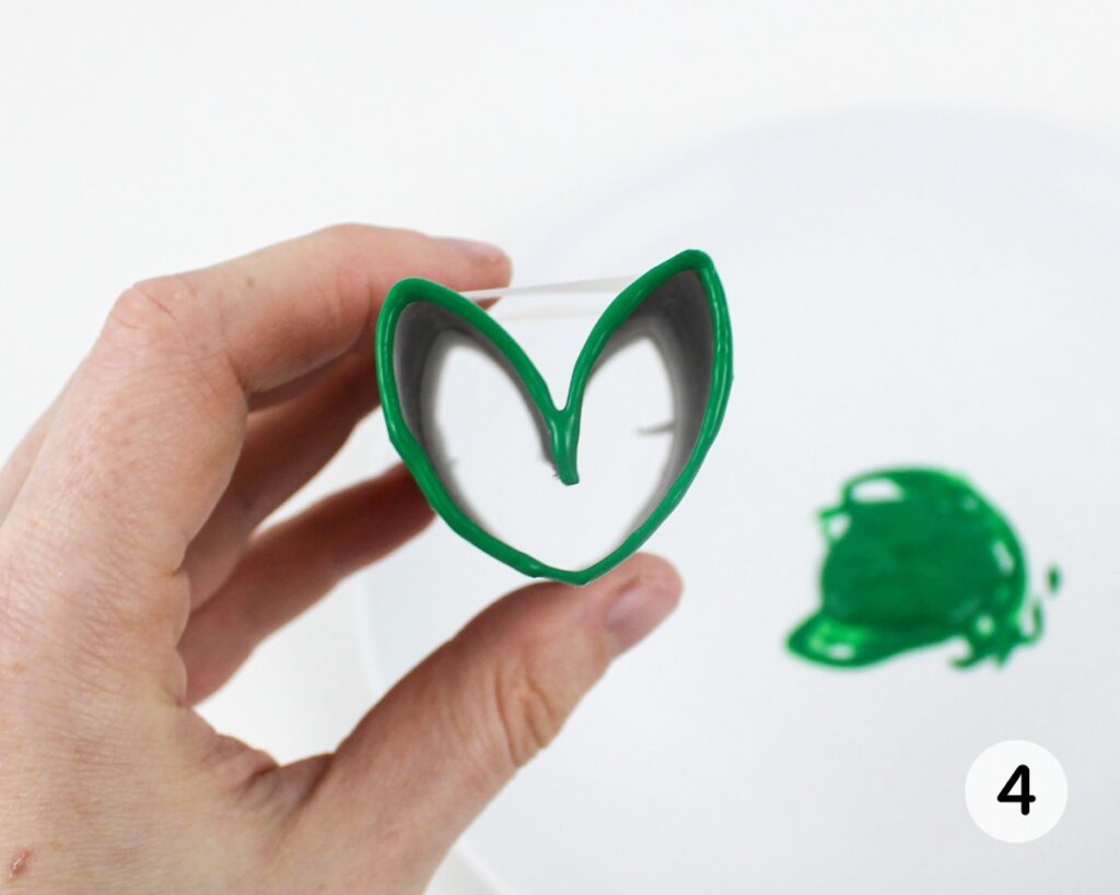 Paper roll heart stamp covered with green paint.