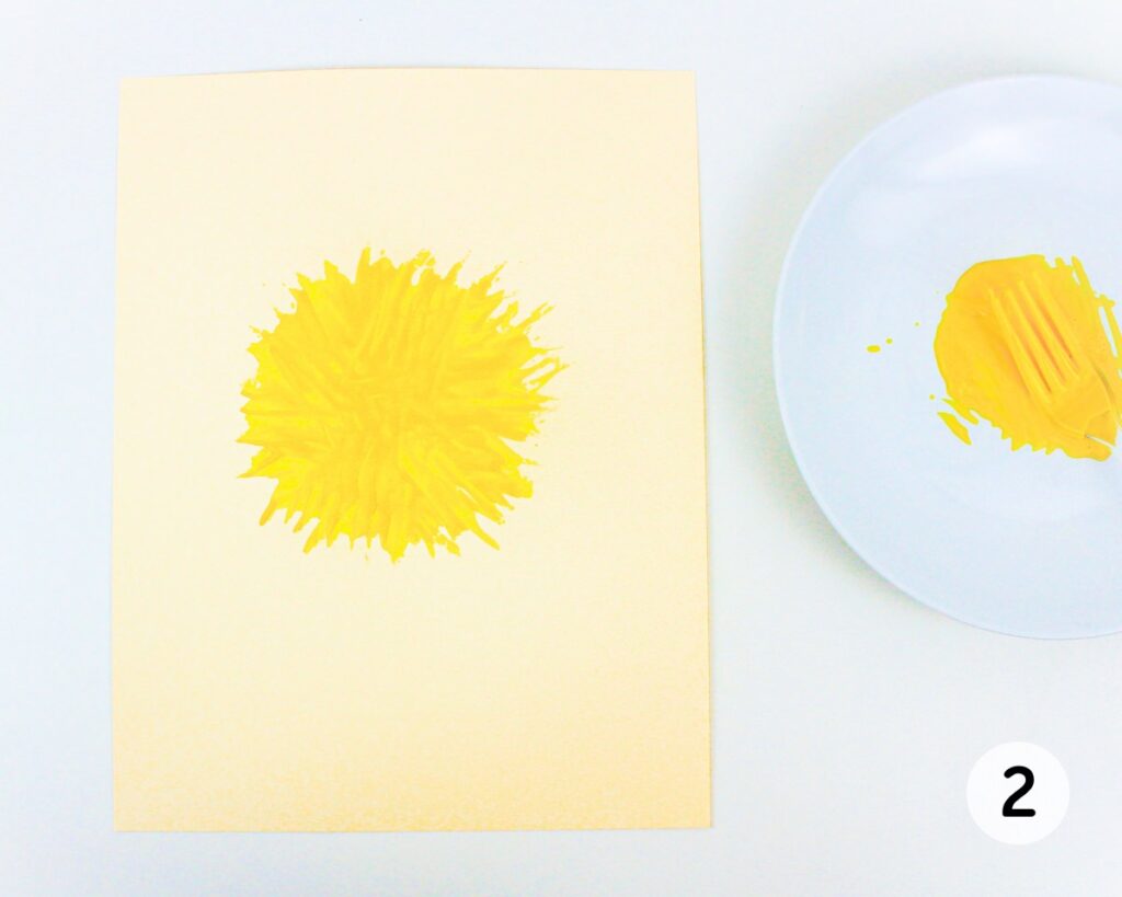 Yellow circle on cardstock, painted with a fork.