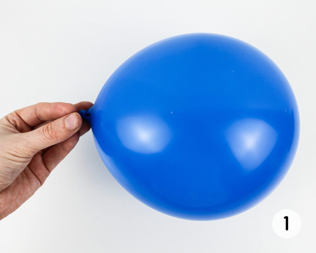 Hand holding an inflated balloon.