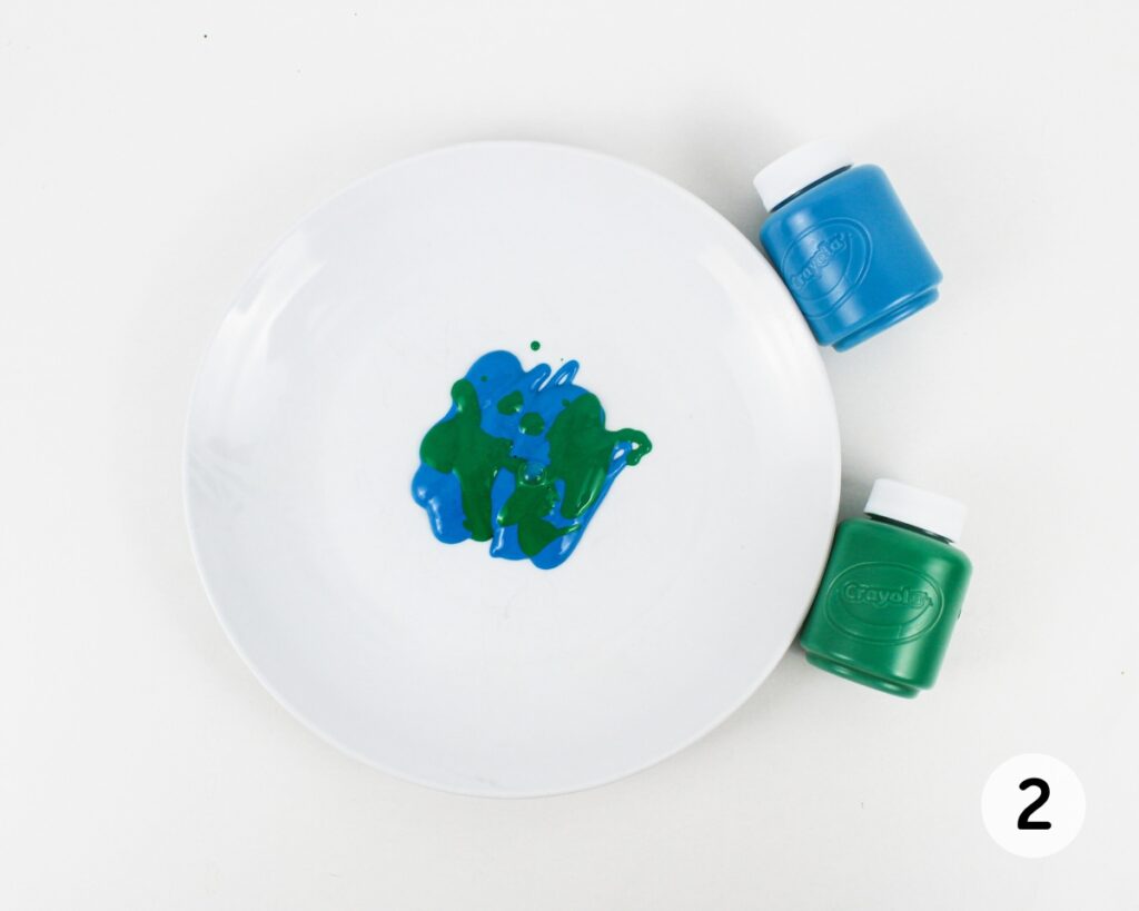 Plate with blue and green paint poured in the middle.