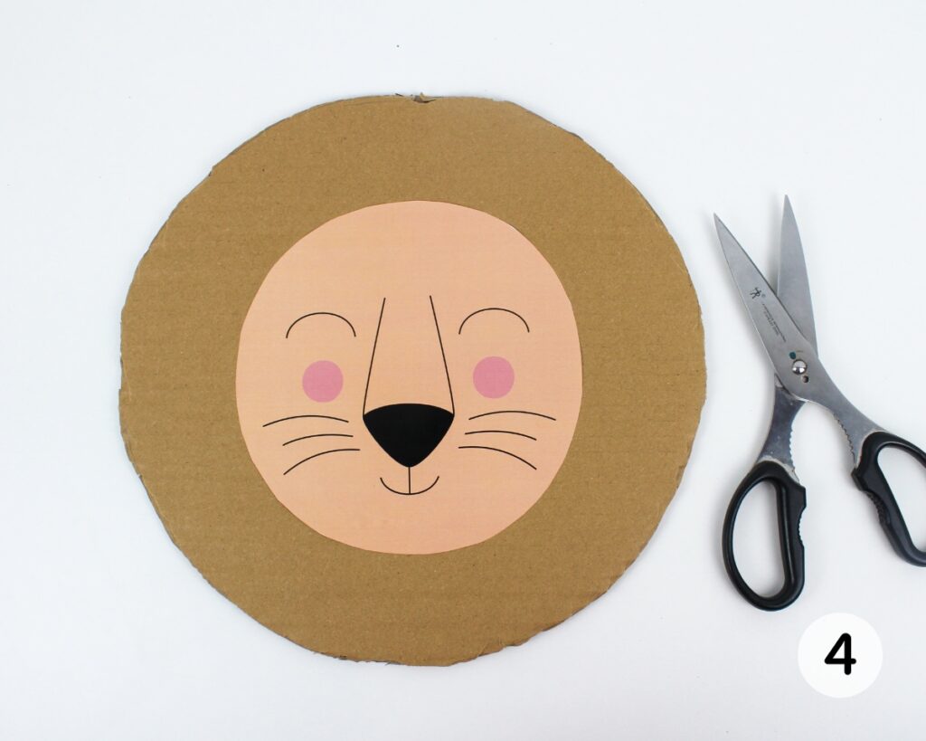Lion face template glued to a round piece of cardboard.