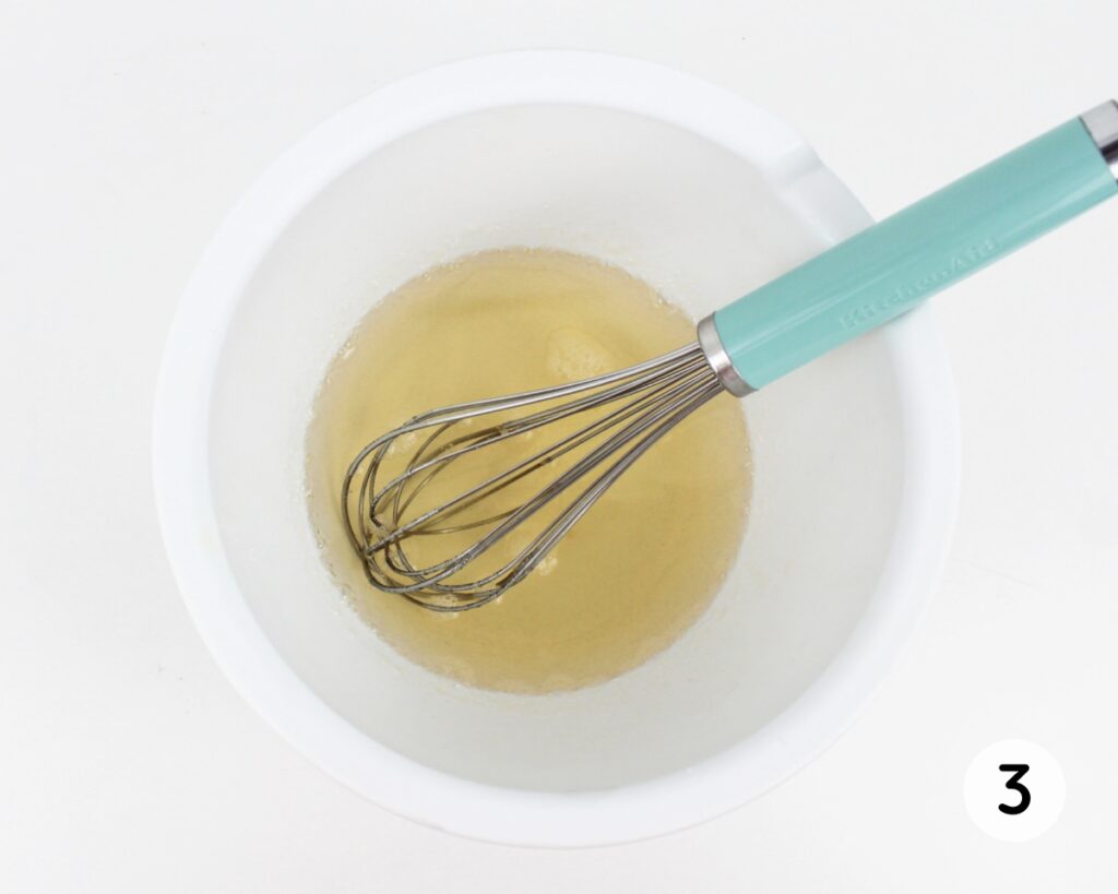 Whisk stirring water and gelatin powder together in a small white bowl.