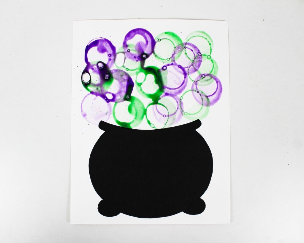 Craft with purple and green bubbles above a black cauldron.