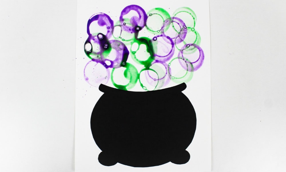 Craft with purple and green bubbles above a black cauldron.