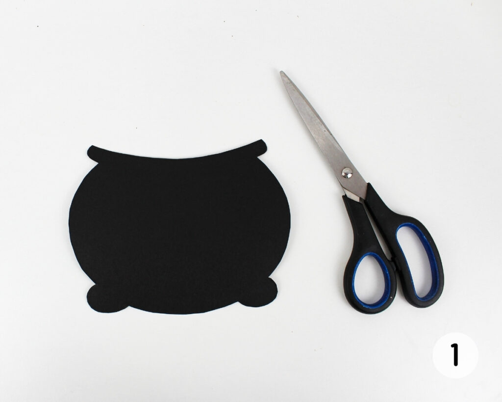 Black cauldron shape cut out with scissors.