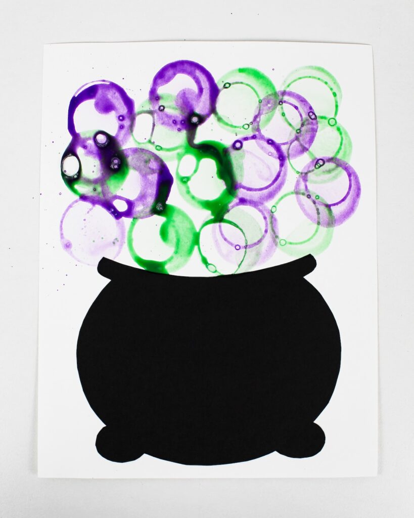 Craft with purple and green bubbles above a black cauldron.